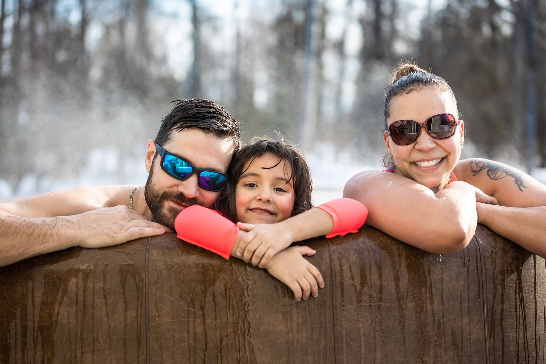 Happy family relaxes in Embers Alaska hot tub