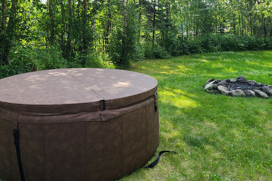 Embers Alaska hot tub set up in backyard with fire pit